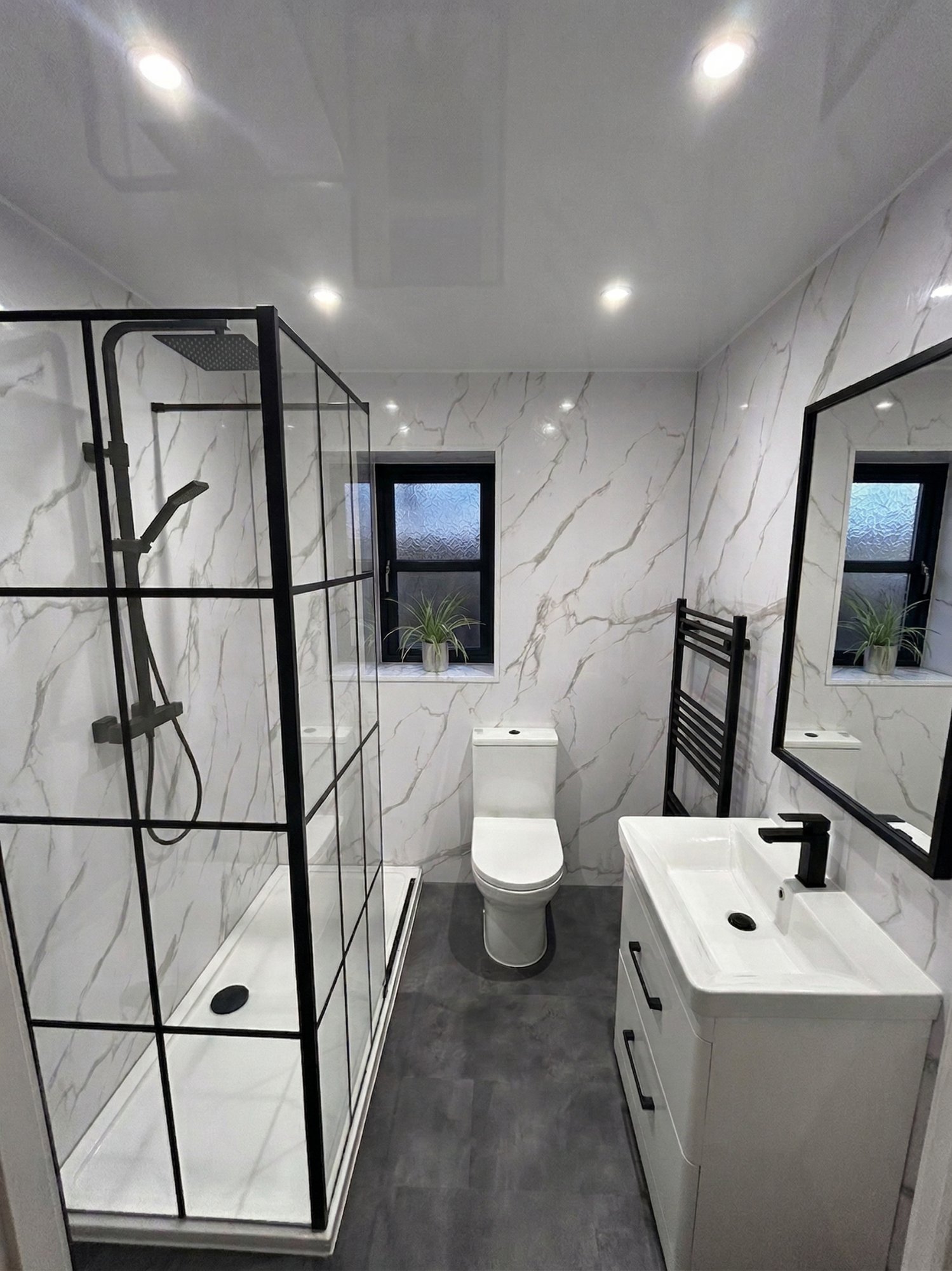 White marble bathroom with black Crittall-style shower screen